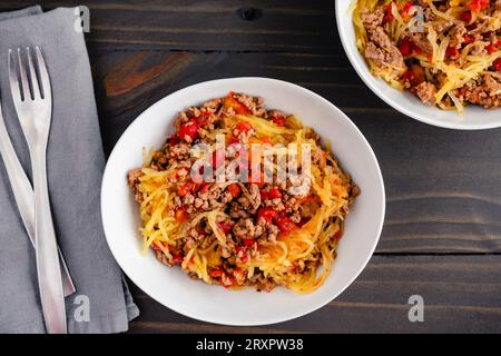 Spaghetti-Kürbis Bolognese mit Tomaten und Hackfleisch: Schüsseln mit Spaghetti-Kürbis, serviert mit Hackfleisch und Tomatensauce Stockfoto