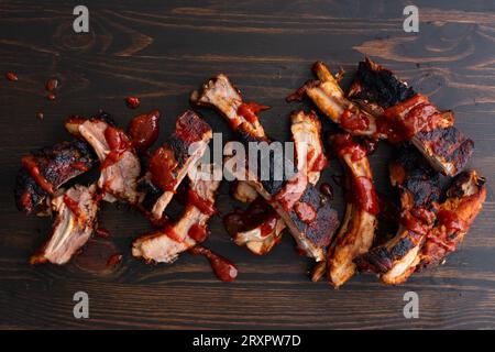 Koreanische Gochujang Baby Back Ribs auf einem hölzernen Hintergrund: Schweinelende Rippchen, gekocht in heißer und würziger koreanischer Fusion-Grillsauce Stockfoto