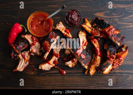 Koreanische Gochujang Baby Back Ribs mit Sauce auf einem hölzernen Hintergrund: Schweinelende Rippchen, gekocht in heißer und würziger koreanischer Fusion-Barbecue-Sauce Stockfoto