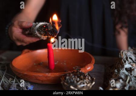 Ein Weihrauch anzünden, eine Hexe am Vorabend aller Heiligen, die ein Reinigungsritual durchführt, Halloween, spirituelle Überzeugungen, weiße Magie Stockfoto