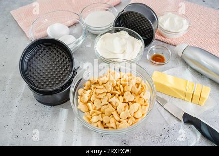 Cracker, Butter, Creamkäse, Eier, Joghurt aus nächster Nähe auf dem Küchentisch. Käsekuchen-Rezept, Zutaten aus nächster Nähe Stockfoto