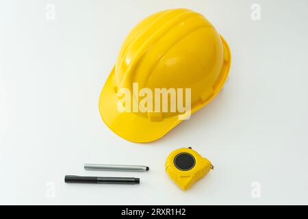 Gelber Schutzhelm und Werkzeuge isoliert auf weißem Hintergrund. Stockfoto