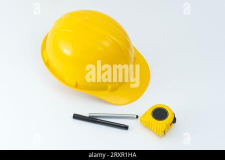 Gelber Schutzhelm und Werkzeuge isoliert auf weißem Hintergrund. Stockfoto