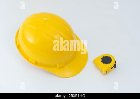 Gelber Schutzhelm und Werkzeuge isoliert auf weißem Hintergrund. Stockfoto