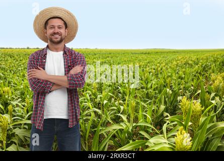 Selbstbewusster Landwirt mit gekreuzten Armen auf dem Feld. Erntesaison Stockfoto