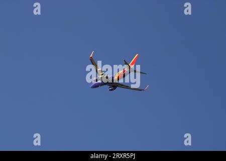 Südwesten 737 fliegen gegen wolkenlosen blauen Himmel, Blick unter den Bauch. Stockfoto