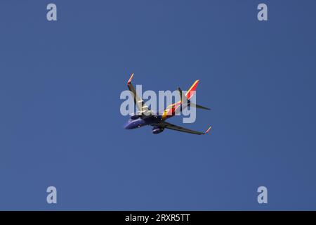 Südwesten 737 fliegen gegen wolkenlosen blauen Himmel, Blick unter den Bauch. Stockfoto