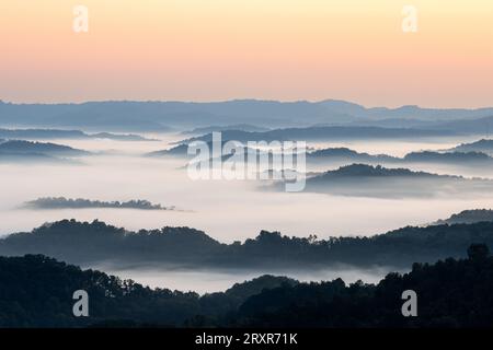 Morgennebel bei Sonnenaufgang über Bergkämmen. Stockfoto