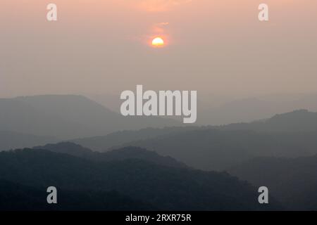 Die Sonne untergeht über Bergrücken. Stockfoto