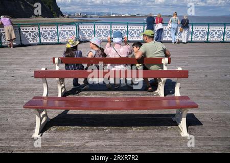 Familie sitzt auf der Bank am Pier in Penarth in Glamorgan South Wales UK Stockfoto