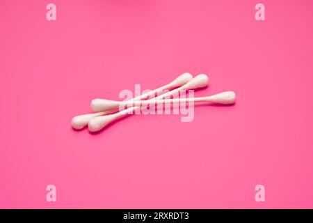 Drei weiße Wattestäbchen auf rosafarbenem Hintergrund Stockfoto