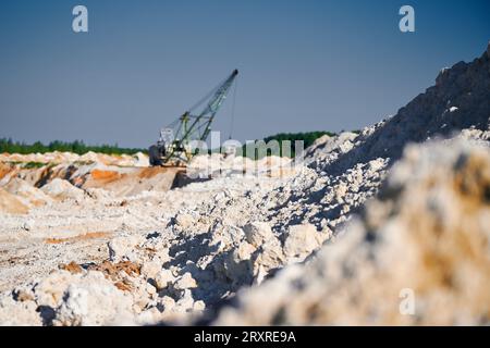 Der wandelnde Bagger wird in der Nähe von Pfahlreihen in der Bergbaugrube betrieben Stockfoto