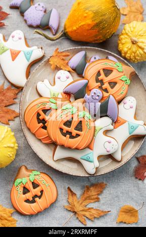 Bunte selbstgemachte Halloween-Kekse auf weißem hölzernem Hintergrund. Stockfoto