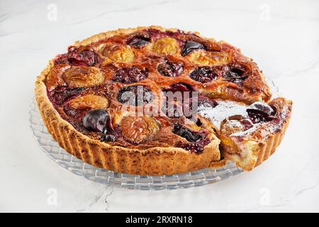 Pflaumenkuchen mit Zimt, auf weißem Hintergrund auf transparenter Schale. Stockfoto