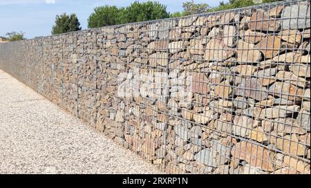 gabionenzaun großer Käfigstein in Maschendrahtwand horizontale Steinfassade Stockfoto