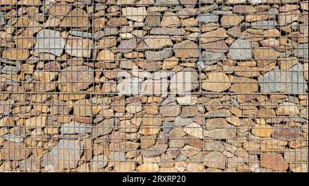 gabion Steine Zaun Fassadenwand Hintergrund der horizontalen Gittersteinwand Tapete Stockfoto