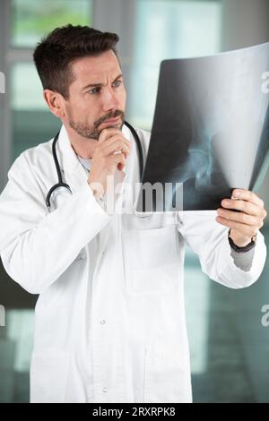 Besorgter Arzt mit Blick auf die Radiographie Stockfoto