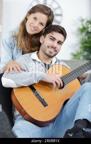 Stattliche mann Lehre schöne Frau akustische Gitarre zu spielen. Stockfoto