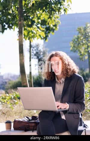 Moderner Geschäftsmann, der im Freien mit einem Laptop arbeitet Stockfoto