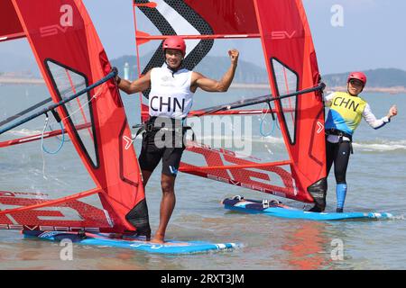 NINGBO, 27. September 2023 (Xinhua) -- BI Kun (L) aus China feiert nach dem Sieg des Men's Windsurfing iQFoil Final of Sailing bei den 19. Asienspielen in Ningbo, ostchinesische Provinz Zhejiang, 27. September 2023. (Xinhua/Zhang Tao) Stockfoto