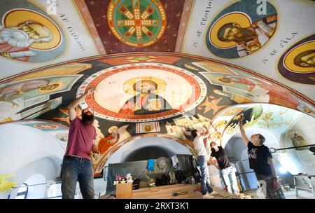 21. September 2023, Sachsen, Leipzig: In der neuen Rumänisch-Orthodoxen Kirche St. Georgs Kirchenmaler aus Bukarest unter der Leitung von Lektor Dr. Mihai Coman (l), Dozent für Kirchenmalerei an der Fakultät für Orthodoxe Theologie der Universität Bukarest, bringen die ersten Fresken auf das Gewölbedach des Kirchenraums nach einer in Deutschland selten verwendeten Technik an. Nach einer Maltechnik, die ihren Ursprung in der Antike hat, müssen bis zu sieben Schichten Kalksand aufgetragen werden, die, gemischt mit Rosshaar oder Hanffilz, garantieren sollen, dass die Fresken Jahrhunderte lang halten. Die Stockfoto