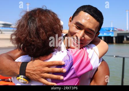 NINGBO, 27. September 2023 (Xinhua) -- BI Kun (R) aus China feiert nach dem Sieg des Men's Windsurfing iQFoil Final of Sailing bei den 19. Asienspielen in Ningbo, ostchinesische Provinz Zhejiang, 27. September 2023. (Xinhua/Zhang Tao) Stockfoto