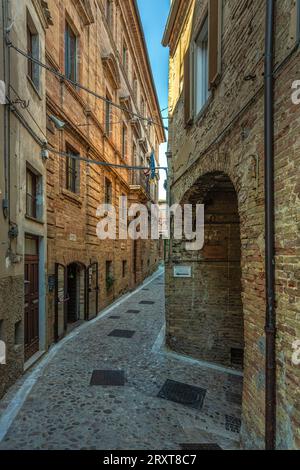 Charakteristische Gasse mit Backsteinhäusern im historischen Zentrum des mittelalterlichen Dorfes Acquaviva Picena. Acquaviva Picena, Region Marken, Italien Stockfoto