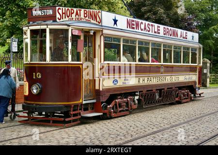 August 2010. Brown 1920s Single Deck Gateshead Tram mit Werbungen für Binns und Newcastle Brown Ale. Beamish, Stanley, Großbritannien. Stockfoto