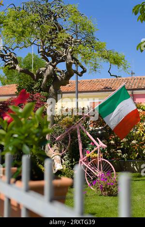 Eine Dekoration mit einem Fahrrad mit italienischer Flagge in Caorle an einem sonnigen Tag Stockfoto