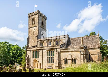 Die Flagge von St. George, die über der Kirche von St. John dem Evangelisten aus dem 14. Jahrhundert im Dorf Taynton in Oxfordshire, England, in Cotswold weht Stockfoto