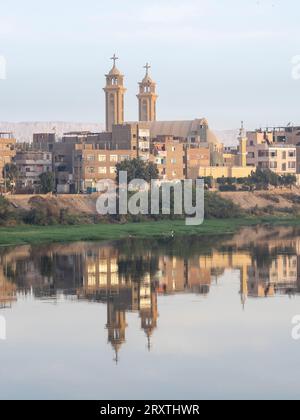 Ein Blick auf die Küste entlang des oberen Nils, mit Stadt und Kirche Reflexion, Dendera, Ägypten, Nordafrika, Afrika Stockfoto