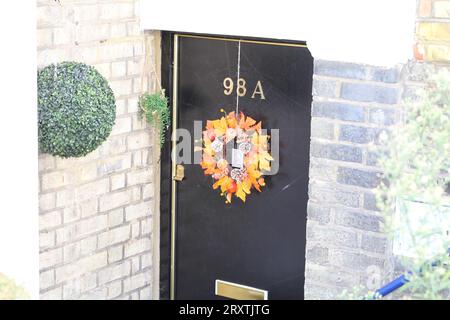 Gelber Blattkranz an einer schwarzen Tür Stockfoto