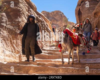 Esel, Reiseleiter und Touristen auf dem Weg zum Petra Kloster (Al Dayr), Petra Archäologischen Park, UNESCO Stockfoto