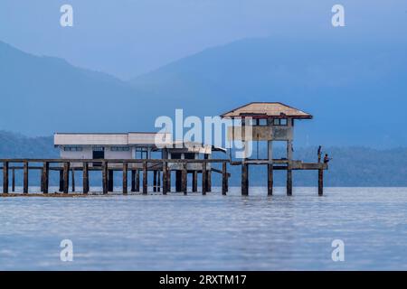 Junge Männer fischen von einem lokalen Gebäude auf Bangka Island, vor der nordöstlichen Spitze von Sulawesi, Indonesien, Südostasien, Asien Stockfoto