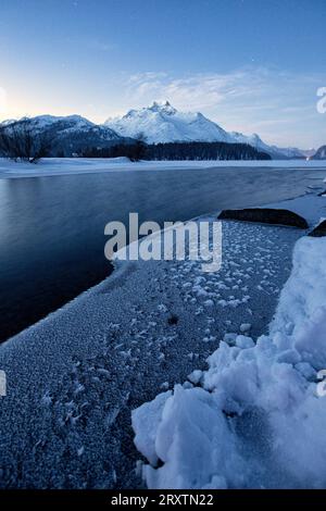 Wintersonnenaufgang über der gefrorenen Oberfläche des Silser Sees im Winter, Engadin, Kanton Graubunden, Schweiz, Europa Stockfoto