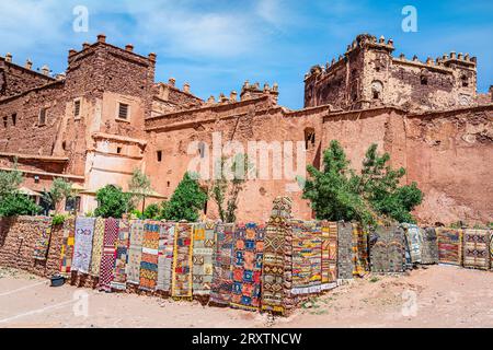 Bunte handgefertigte Teppiche zum Verkauf hängen vor den alten Ruinen von Telouet Kasbah, Hohen Atlas Berge, Marokko, Nordafrika, Afrika Stockfoto