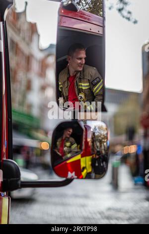 Feuerwehrmann im Spiegel am Tatort eines Vorfalls in London. Stockfoto