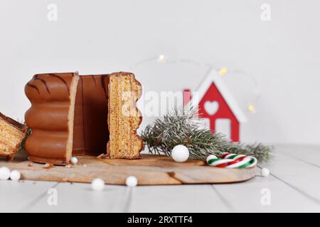 Offener Kuchen mit dem Namen „Baumkuchen“, ein mit Schokolade glasierter deutscher Mehrschichtkuchen, umgeben von saisonalen Dekorationen Stockfoto