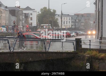 Cork, Irland, 27. September 2023. DC 27-9-23, Cork City Centre, Kunden und Pendler treffen auf Storm Agnes Head-On, Cork, Irland. Während Storm Agnes nach Irland fliegt, gehen Käufer und Pendler im Stadtzentrum von Cork trotz des Wetters weiter. Trotz der Regen- und Windwarnung von Eireann, die den Status Orange erhielt, beharrten die Menschen in Kork. Quelle: Damian Coleman/Alamy Live News Stockfoto