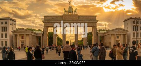 Blick auf die Menschen, die sich am Brandenburger Tor bei Sonnenuntergang, Pariser Platz, unter den Linden, Berlin, Deutschland versammelt haben, Europa Stockfoto