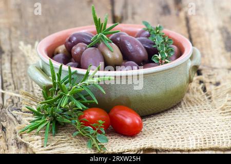 Rote kalamata Oliven, Tomaten und Kräuter in einer Schüssel Stockfoto