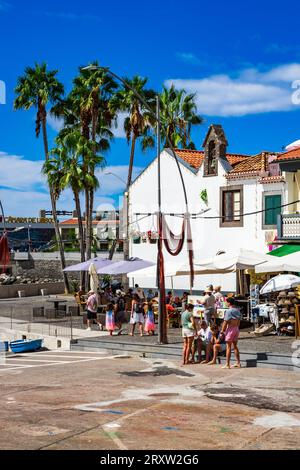 Malerischer Blick auf das kleine Fischerdorf Câmara de Lobos in Madeira, Portugal, wo Touristen das Hafenleben an der Uferpromenade genießen Stockfoto