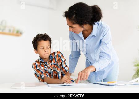 Wütend Strenge Lehrerin Lady Schimpft Schuljunge Zeigt Auf Copybook Drinnen Stockfoto