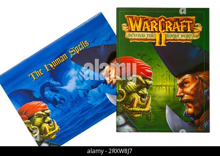 Warcraft II Tides of Darkness Deluxe-Computerspiel, Warcraft II Beyond the Dark Portal Buch und The Human Spells Buch auf weißem Hintergrund Stockfoto