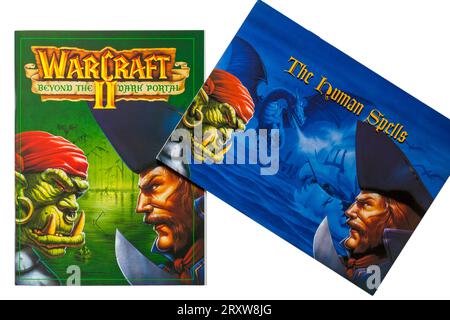 Warcraft II Tides of Darkness Deluxe-Computerspiel, Warcraft II Beyond the Dark Portal Buch und The Human Spells Buch auf weißem Hintergrund Stockfoto