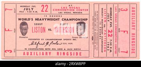 Ticket für das Boxspiel der World Heaveywieght Championship zwischen Floyd Patterson und Sonny Liston. Das Ticket ist hellrot mit rotem und schwarzem Text. Der Text wird sowohl horizontal als auch vertikal auf dem Ticket angezeigt. In der Mitte links befindet sich ein schwarz-weißes Bild von Sonny Liston. In der Mitte rechts befindet sich ein schwarz-weißes Bild von Floyd Patterson. Der Text in der Mitte beginnt „15 RUNDEN / WORLD’s HEAVYWEIGHT CHAMPIONSHIP…“ Stockfoto