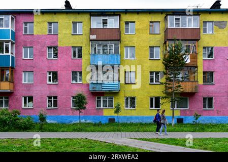 Zwei russische Teenager und ein farbenfroher Appartementhaus im sowjetischen Stil in Petropawlowsk-Kamtschatskij, Region Kamtschatka, Russland. Sommer 2015 Stockfoto