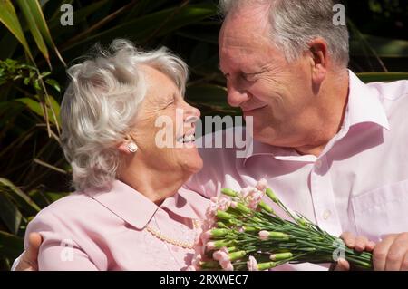 Glücklich verheiratetes Seniorenpaar posiert vor der Kamera - John Gollop Stockfoto