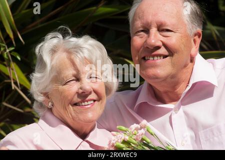 Glücklich verheiratetes Seniorenpaar posiert vor der Kamera - John Gollop Stockfoto