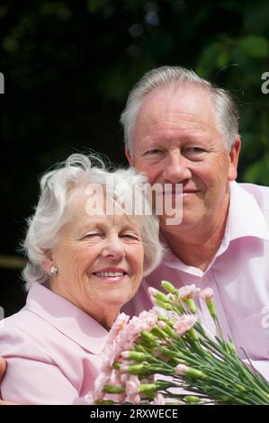 Glücklich verheiratetes Seniorenpaar posiert vor der Kamera - John Gollop Stockfoto